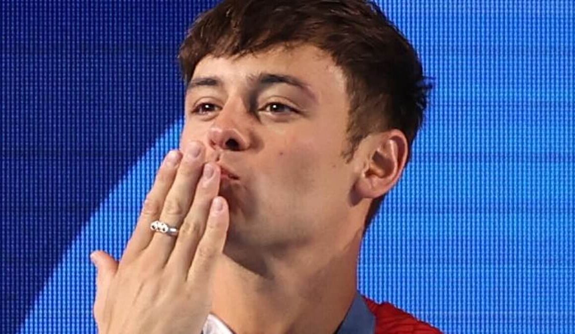 ‘It’s very moving’: Tom Daley’s husband Dustin Lance Black chokes back tears as he says it was ‘so special’ for their sons to watch their father win a silver medal – as Team GB star blows them kisses from the podium