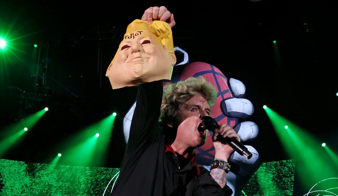 Green Day frontman Billie Joe Armstrong is slammed for holding up Donald Trump HEAD mask during DC concert