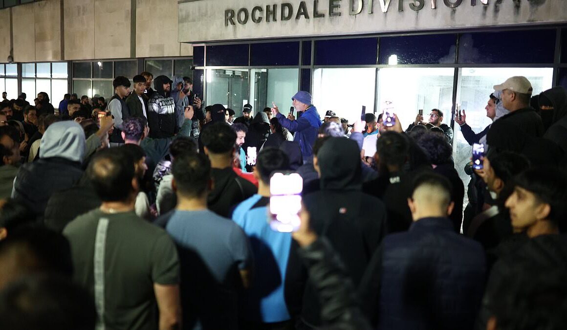 Crowd of hundreds mass overnight outside police station where men from Manchester Airport video were taken after chaotic incident where cop kicked and stamped on man’s head chanting ‘GMP shame on you’