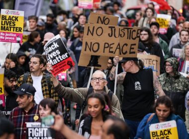 Crowds of protesters block roads and trams in Manchester city centre branding police ‘racist’ and calling for cops to be sacked over airport ‘kicking and stamping’ attack – as watchdog opens second probe and sets up witness hotline