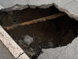 Huge 10ft wide sinkhole in middle of town ignites safety fears as motorists mount pavements and drive the WRONG way to swerve it