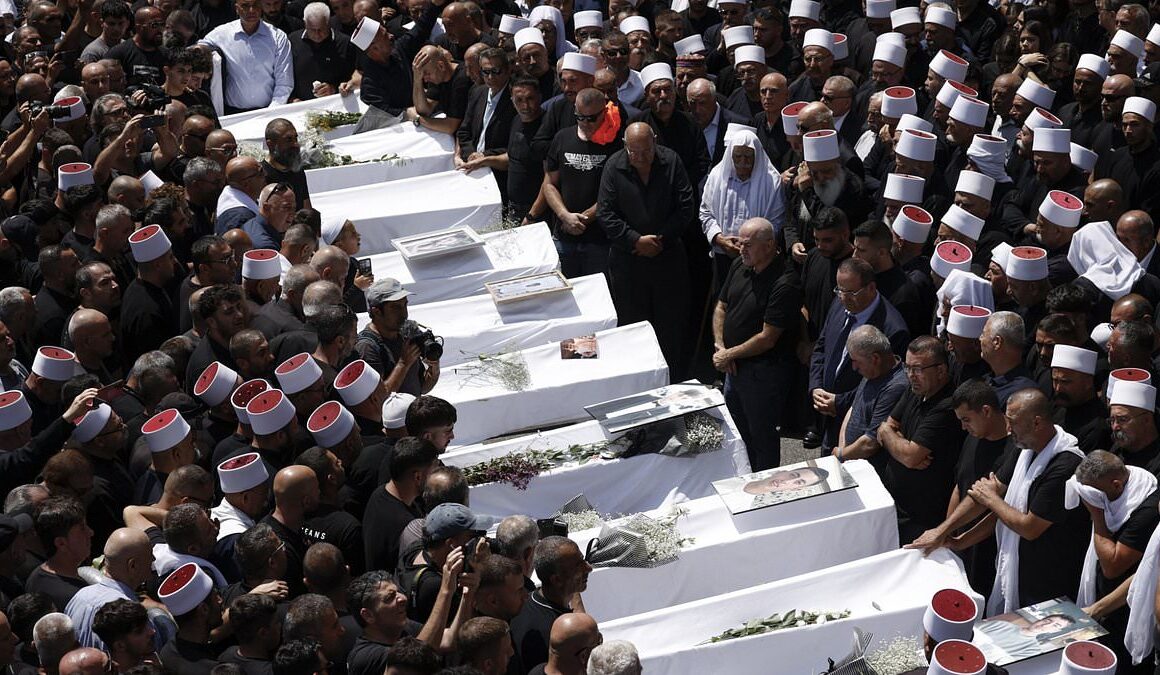 Thousands of mourners gather for funerals of children after ‘at least 12’ killed by Hezbollah rocket attack on football field at Israeli-controlled Golan Heights – as IDF chief vows ‘very significant reaction’ to onslaught