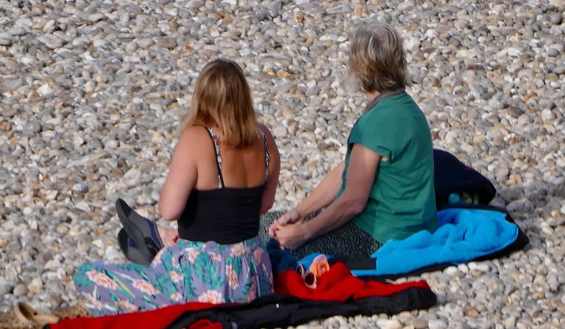 UK’s heatwave eases off but families flock to beaches to catch the day’s early sun as highs of milder 23C predicted