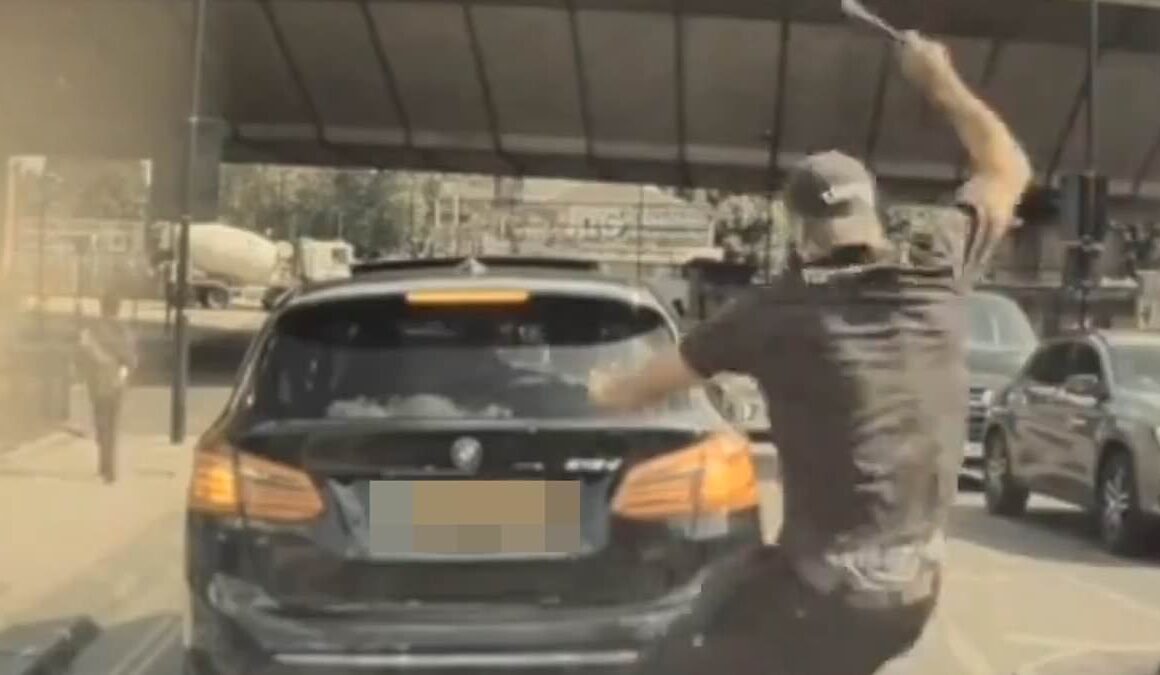 Shocking moment tradesman smashes a driver’s car window with a hammer after road rage row in the middle of a junction in London