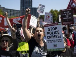 Some protesters tear down security fence as thousands march outside Democratic National Convention