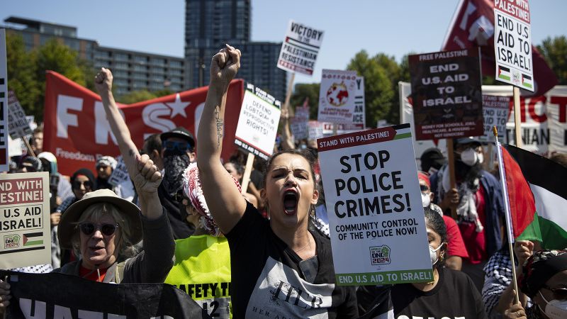 Some protesters tear down security fence as thousands march outside Democratic National Convention